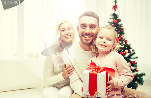 Image of happy family at home with christmas gift box