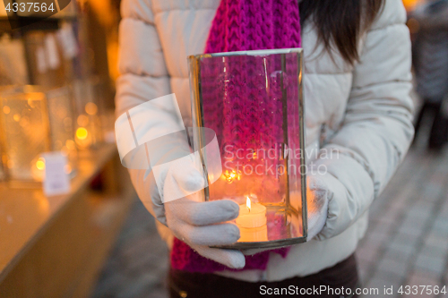 Image of woman with candle in lantern at christmas market