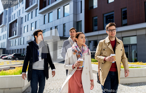 Image of people with coffee and conference badges in city