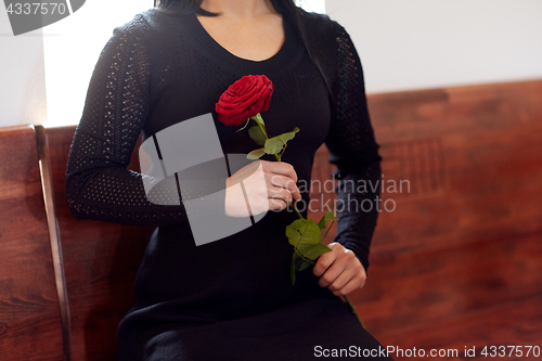 Image of close up of woman with roses at funeral in church