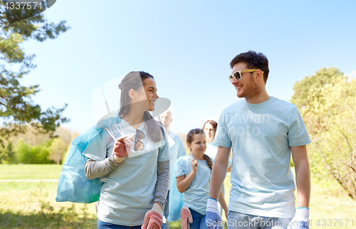 Image of volunteers with garbage bags talking outdoors