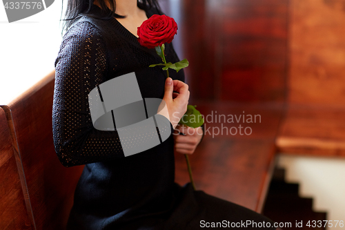 Image of close up of woman with roses at funeral in church