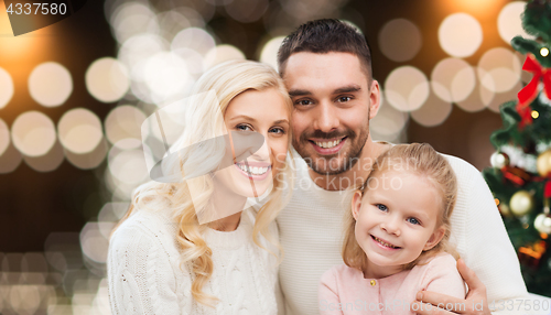 Image of happy family at home with christmas tree