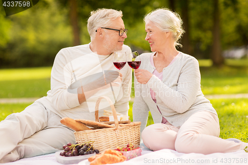 Image of happy senior couple having picnic at summer park