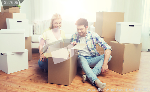 Image of smiling couple with big boxes moving to new home