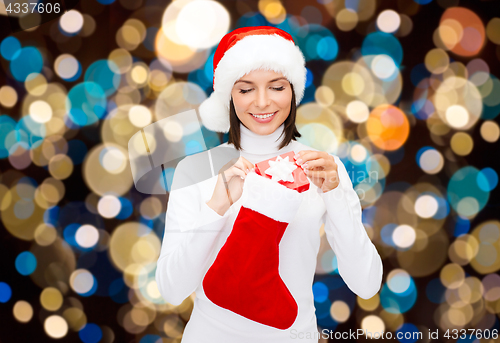 Image of woman in santa hat with christmas gift and sock