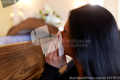 Image of woman with coffin crying at funeral in church