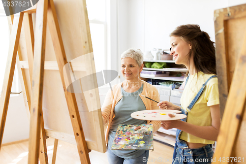 Image of women with easels and palettes at art school