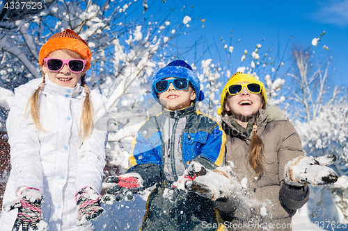 Image of Happy little children playing  in winter snow day.