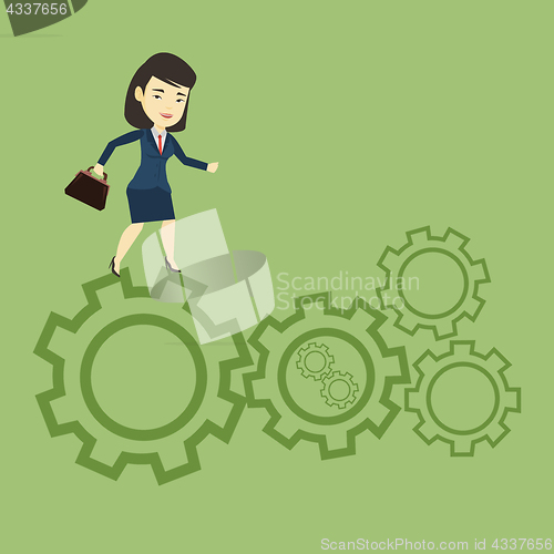 Image of Business woman running on cogwheels.