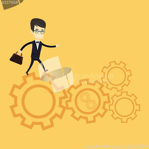 Image of Business man running on cogwheels.