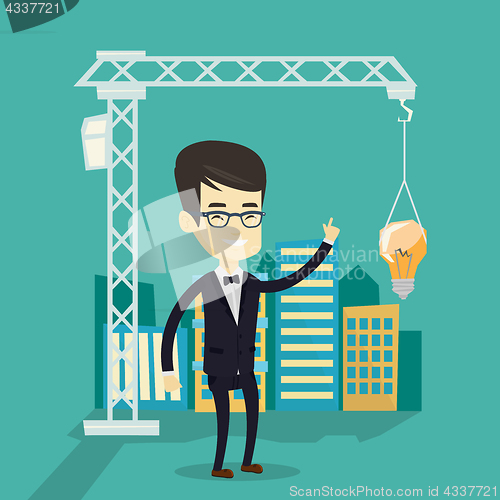 Image of Man pointing at idea bulb hanging on crane.