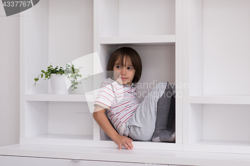 Image of young boy posing on a shelf