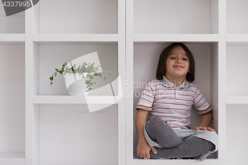 Image of young boy posing on a shelf