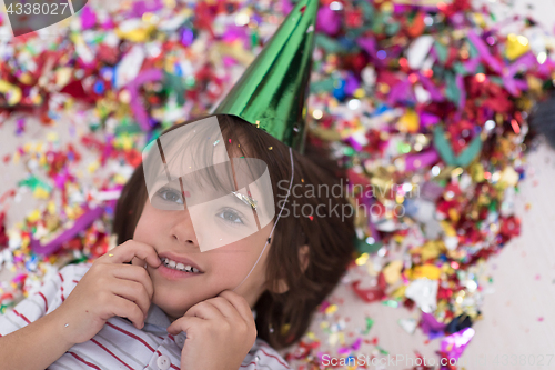 Image of kid blowing confetti while lying on the floor