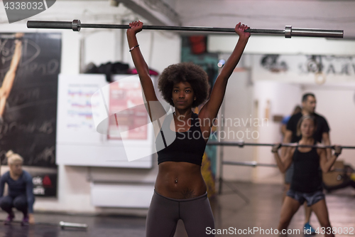 Image of black woman lifting empty bar