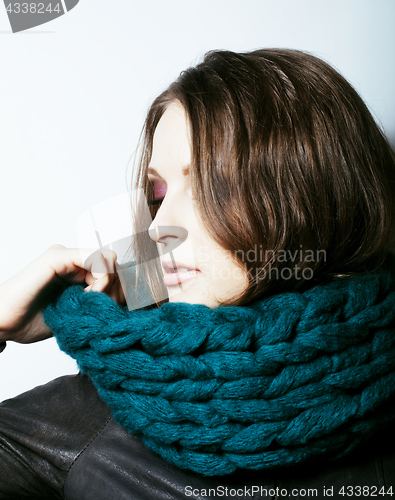 Image of young pretty real woman in sweater and scarf all over her face s