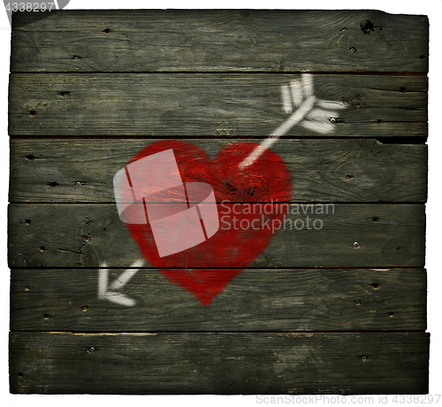 Image of painted heart with arrow on old wooden planks