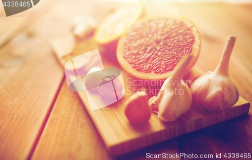 Image of garlic and grapefruit on wooden board