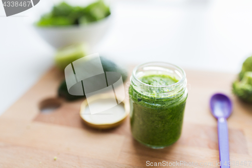 Image of jar with puree or baby food on wooden board