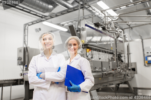 Image of happy women technologists at ice cream factory