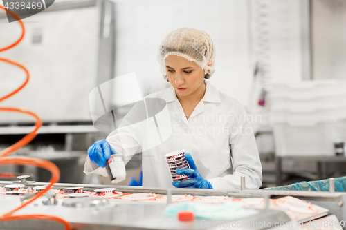 Image of woman working at ice cream factory conveyor