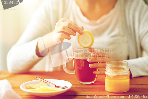 Image of close up of ill woman drinking tea with lemon