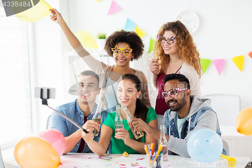 Image of happy team taking selfie at office party