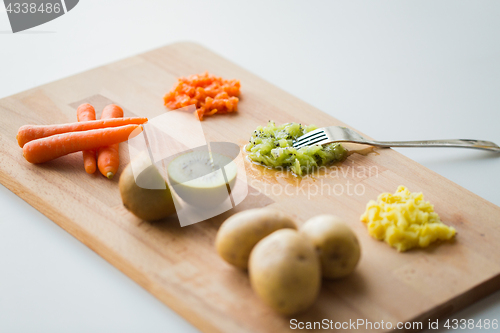 Image of mashed fruits and vegetables with forks on board