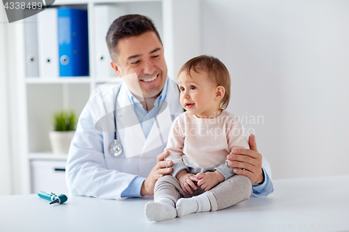 Image of happy doctor or pediatrician with baby at clinic