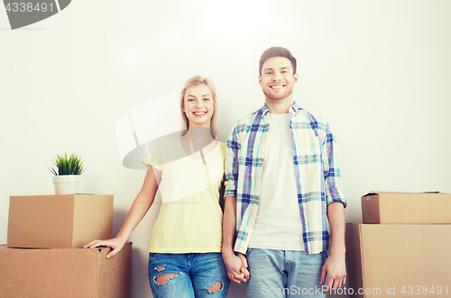 Image of smiling couple with big boxes moving to new home