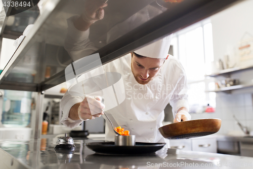 Image of happy male chef cooking food at restaurant kitchen