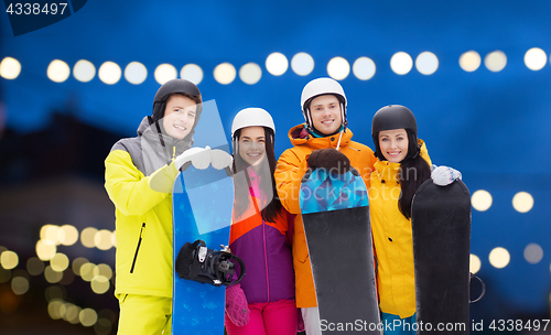 Image of happy friends in helmets with snowboards