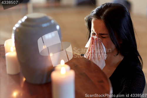 Image of woman with cremation urn at funeral in church
