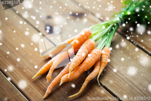 Image of close up of carrot bunch on wooden table