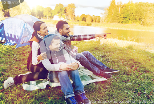 Image of happy family with tent at camp site