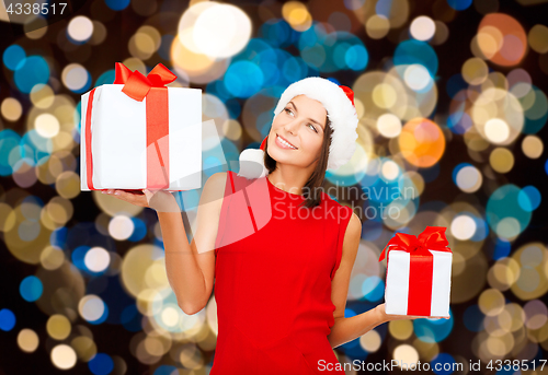 Image of smiling woman in santa hat with christmas gifts