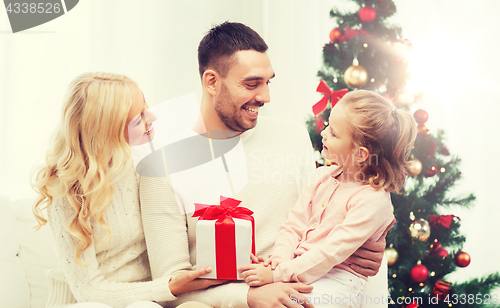 Image of happy family at home with christmas tree