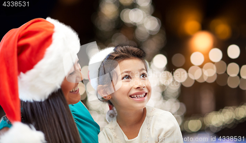 Image of mother and daughter in santa hats at christmas