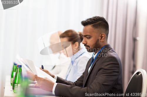 Image of businessman with files at international conference