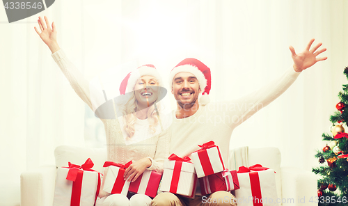 Image of happy couple at home with christmas gift boxes