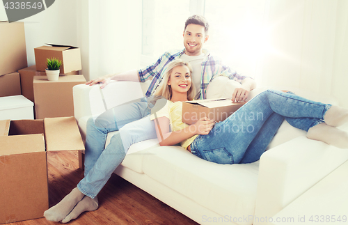 Image of happy couple with big cardboard boxes at new home