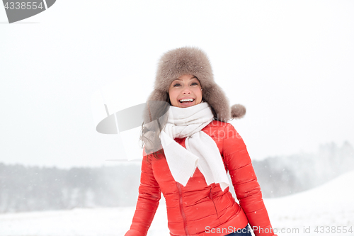 Image of happy woman in winter fur hat outdoors