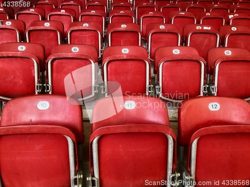 Image of Empty red plastic seats in a stadium