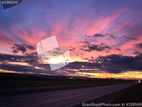 Image of A plane is approaching Stuttgart AIrport during a dramatic sunset