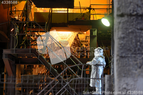 Image of Molten Metal Pouring Out Of Furnace and Workers