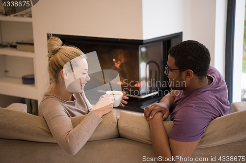 Image of Young multiethnic couple  in front of fireplace