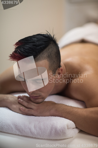 Image of handsome man resting in a spa massage center