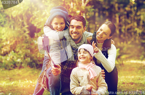 Image of happy family with smartphone selfie stick in woods