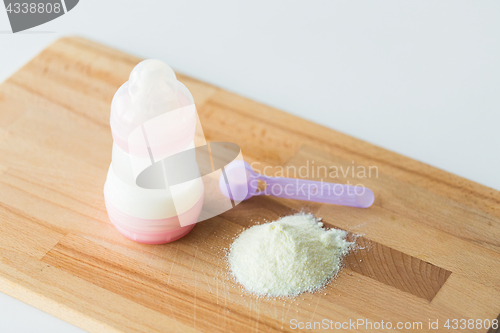 Image of infant formula, baby bottle and scoop on board